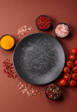 Yemek için boş yuvarlak siyah tabak, yemek masasında mutfak gereçleri. Koyu arkaplanda boş tabak