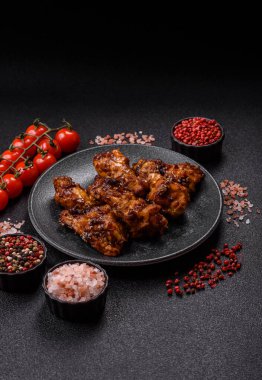 Izgara ya da ızgara tavuk kanadı, teriyaki sosu, baharat ve susam tohumuyla. Koyu arkaplanda tuz ve baharatlı Teriyaki tavuğu