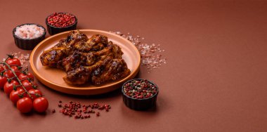 Izgara ya da ızgara tavuk kanadı, teriyaki sosu, baharat ve susam tohumuyla. Koyu arkaplanda tuz ve baharatlı Teriyaki tavuğu