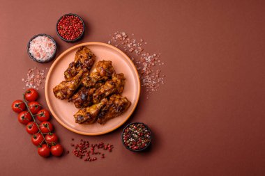 Izgara ya da ızgara tavuk kanadı, teriyaki sosu, baharat ve susam tohumuyla. Koyu arkaplanda tuz ve baharatlı Teriyaki tavuğu