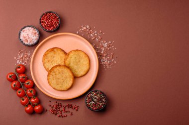 Mücver, patates, soğan ve sebzeden yapılmış kahvaltı yemeği. Koyu beton arka planda patates, tuz ve baharatlı mücver.