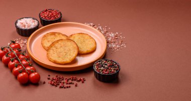 Mücver, patates, soğan ve sebzeden yapılmış kahvaltı yemeği. Koyu beton arka planda patates, tuz ve baharatlı mücver.