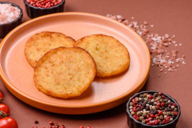 Mücver, patates, soğan ve sebzeden yapılmış kahvaltı yemeği. Koyu beton arka planda patates, tuz ve baharatlı mücver.