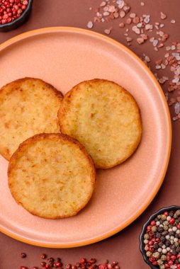 Mücver, patates, soğan ve sebzeden yapılmış kahvaltı yemeği. Koyu beton arka planda patates, tuz ve baharatlı mücver.