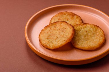 Mücver, patates, soğan ve sebzeden yapılmış kahvaltı yemeği. Koyu beton arka planda patates, tuz ve baharatlı mücver.