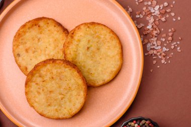 Mücver, patates, soğan ve sebzeden yapılmış kahvaltı yemeği. Koyu beton arka planda patates, tuz ve baharatlı mücver.