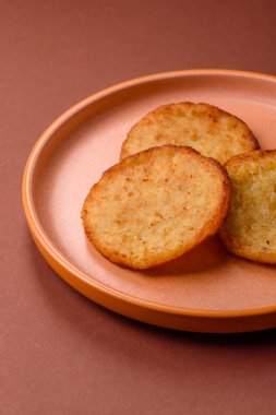 Mücver, patates, soğan ve sebzeden yapılmış kahvaltı yemeği. Koyu beton arka planda patates, tuz ve baharatlı mücver.