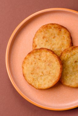 Mücver, patates, soğan ve sebzeden yapılmış kahvaltı yemeği. Koyu beton arka planda patates, tuz ve baharatlı mücver.