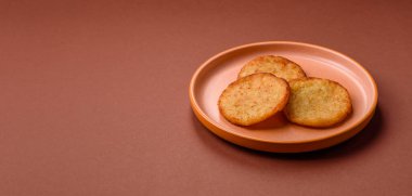 Mücver, patates, soğan ve sebzeden yapılmış kahvaltı yemeği. Koyu beton arka planda patates, tuz ve baharatlı mücver.