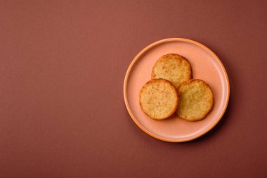 Mücver, patates, soğan ve sebzeden yapılmış kahvaltı yemeği. Koyu beton arka planda patates, tuz ve baharatlı mücver.