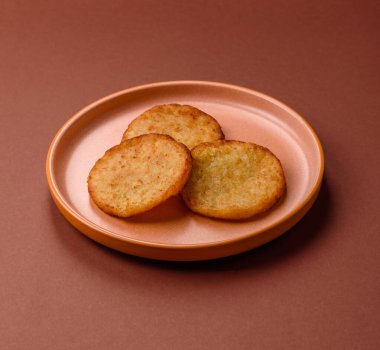 Mücver, patates, soğan ve sebzeden yapılmış kahvaltı yemeği. Koyu beton arka planda patates, tuz ve baharatlı mücver.