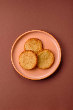 Mücver, patates, soğan ve sebzeden yapılmış kahvaltı yemeği. Koyu beton arka planda patates, tuz ve baharatlı mücver.