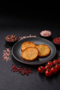 Mücver, patates, soğan ve sebzeden yapılmış kahvaltı yemeği. Koyu beton arka planda patates, tuz ve baharatlı mücver.