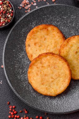 Mücver, patates, soğan ve sebzeden yapılmış kahvaltı yemeği. Koyu beton arka planda patates, tuz ve baharatlı mücver.