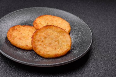 Mücver, patates, soğan ve sebzeden yapılmış kahvaltı yemeği. Koyu beton arka planda patates, tuz ve baharatlı mücver.