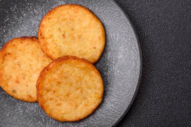 Mücver, patates, soğan ve sebzeden yapılmış kahvaltı yemeği. Koyu beton arka planda patates, tuz ve baharatlı mücver.