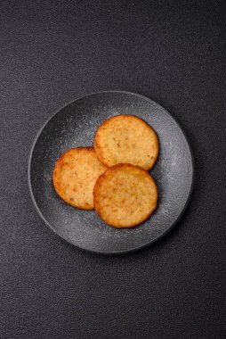 Mücver, patates, soğan ve sebzeden yapılmış kahvaltı yemeği. Koyu beton arka planda patates, tuz ve baharatlı mücver.