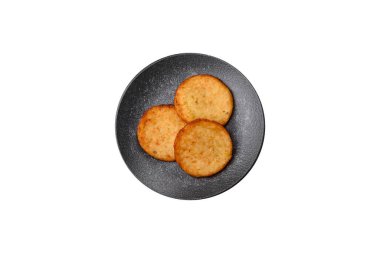 Mücver, patates, soğan ve sebzeden yapılmış kahvaltı yemeği. Koyu beton arka planda patates, tuz ve baharatlı mücver.