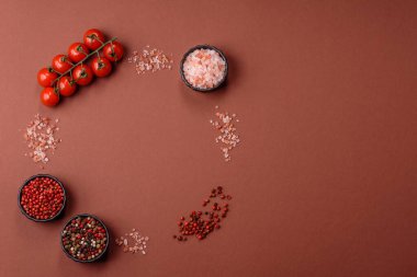 Koyu beton zeminde domates, tuz, baharat ve otlar pişirmek için gerekli malzemeler.