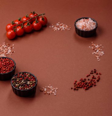 Koyu beton zeminde domates, tuz, baharat ve otlar pişirmek için gerekli malzemeler.