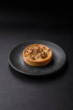 Turta ya da kiş, ekşi bir tart tavuk ve mantarla, baharatlar ve otlar koyu beton arka planda. Tavuklu yuvarlak kiş.