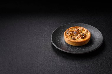 Turta ya da kiş, ekşi bir tart tavuk ve mantarla, baharatlar ve otlar koyu beton arka planda. Tavuklu yuvarlak kiş.