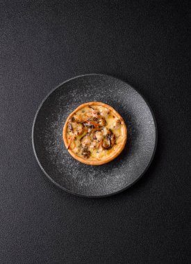 Turta ya da kiş, ekşi bir tart tavuk ve mantarla, baharatlar ve otlar koyu beton arka planda. Tavuklu yuvarlak kiş.