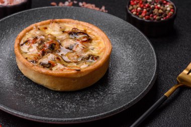 Turta ya da kiş, ekşi bir tart tavuk ve mantarla, baharatlar ve otlar koyu beton arka planda. Tavuklu yuvarlak kiş.