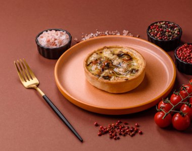 Turta ya da kiş, ekşi bir tart tavuk ve mantarla, baharatlar ve otlar koyu beton arka planda. Tavuklu yuvarlak kiş.