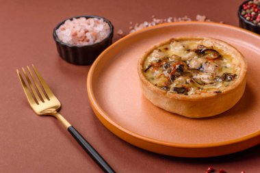 Turta ya da kiş, ekşi bir tart tavuk ve mantarla, baharatlar ve otlar koyu beton arka planda. Tavuklu yuvarlak kiş.