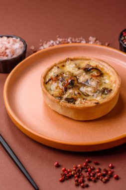 Turta ya da kiş, ekşi bir tart tavuk ve mantarla, baharatlar ve otlar koyu beton arka planda. Tavuklu yuvarlak kiş.