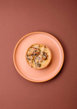 Turta ya da kiş, ekşi bir tart tavuk ve mantarla, baharatlar ve otlar koyu beton arka planda. Tavuklu yuvarlak kiş.