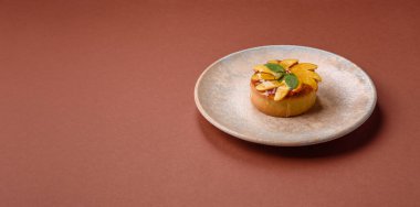 Elmalı, şeftalili, kremalı ve fındıklı tatlı turta. Meyve dilimli mini tatlı tart.