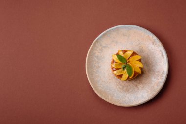 Elmalı, şeftalili, kremalı ve fındıklı tatlı turta. Meyve dilimli mini tatlı tart.