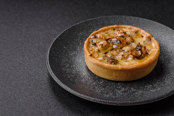 Turta ya da kiş, ekşi bir tart tavuk ve mantarla, baharatlar ve otlar koyu beton arka planda. Tavuklu yuvarlak kiş.