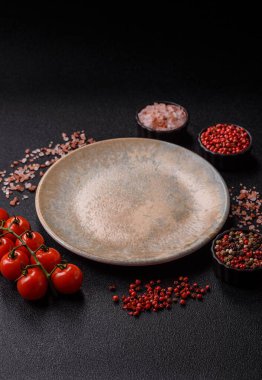 Tek renkli kahverengi arka planda boş seramik plaka. Yemek masasında çatal bıçak takımı olan boş bir tabak.