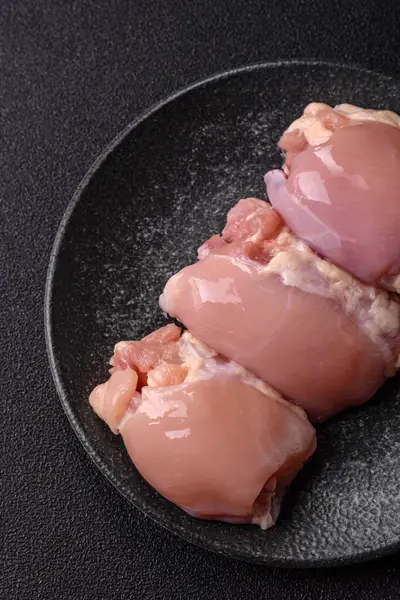 Çiğ tavuk budu fileto derisi ve kemiği olmadan tuz ve baharatla pişirmek için hazırlandı. Evde pişirmek için çiğ tavuk filetosu.
