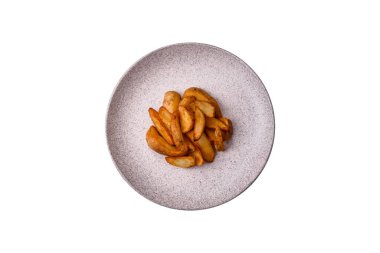 Biberiye, peynir, tuz ve baharatlı ızgara patates dilimleri. Koyu beton zeminde fırında patates dilimleri.