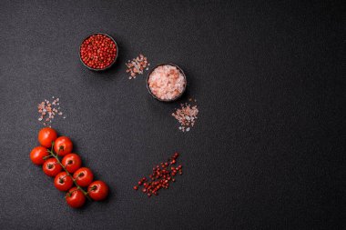 Koyu beton zeminde domates, tuz, baharat ve otlar pişirmek için gerekli malzemeler.