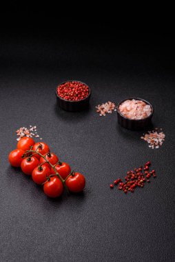 Koyu beton zeminde domates, tuz, baharat ve otlar pişirmek için gerekli malzemeler.