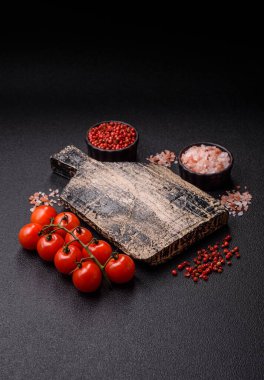 Koyu beton zeminde domates, tuz, baharat ve otlar pişirmek için gerekli malzemeler.