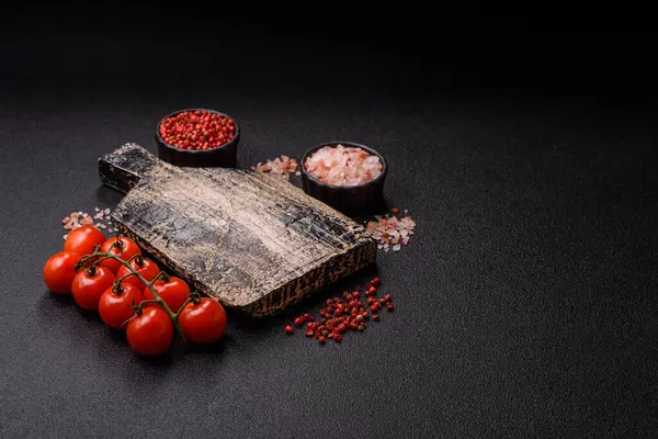 Koyu beton zeminde domates, tuz, baharat ve otlar pişirmek için gerekli malzemeler.