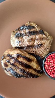 Tuz ve biberli ızgara biftek eti. Biftek ızgarada ızgara. Tasarımın için arka plan olarak.