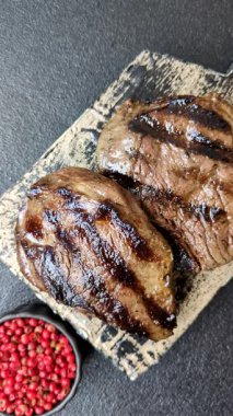 Tuz ve biberli ızgara biftek eti. Biftek ızgarada ızgara. Tasarımın için arka plan olarak.