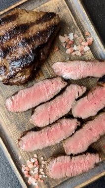 Tuz ve biberli ızgara biftek eti. Biftek ızgarada ızgara. Tasarımın için arka plan olarak.