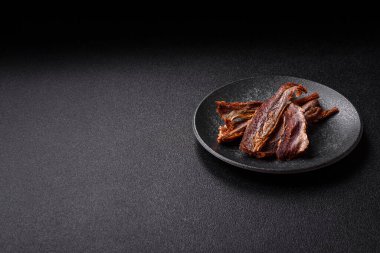 Atıştırmalık olarak kurutulmuş balık veya kurutulmuş et, dilimlenmiş deniz ürünleri. Tasarımınız için arka plan olarak kurutulmuş deniz ürünleri atıştırmalıkları