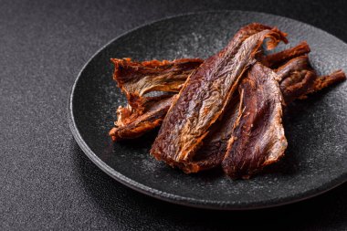 Atıştırmalık olarak kurutulmuş balık veya kurutulmuş et, dilimlenmiş deniz ürünleri. Tasarımınız için arka plan olarak kurutulmuş deniz ürünleri atıştırmalıkları