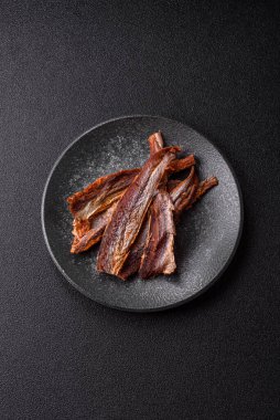 Atıştırmalık olarak kurutulmuş balık veya kurutulmuş et, dilimlenmiş deniz ürünleri. Tasarımınız için arka plan olarak kurutulmuş deniz ürünleri atıştırmalıkları