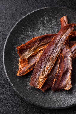 Atıştırmalık olarak kurutulmuş balık veya kurutulmuş et, dilimlenmiş deniz ürünleri. Tasarımınız için arka plan olarak kurutulmuş deniz ürünleri atıştırmalıkları