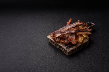 Atıştırmalık olarak kurutulmuş balık veya kurutulmuş et, dilimlenmiş deniz ürünleri. Tasarımınız için arka plan olarak kurutulmuş deniz ürünleri atıştırmalıkları